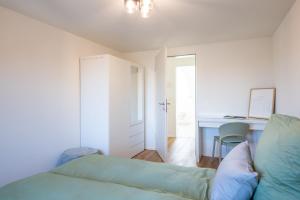 a living room with a couch and a desk at Sali Suite - Modern Attic Stay in Arbon