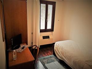 a bedroom with a desk with a computer and a bed at Albergo Volpara in Mussolente 