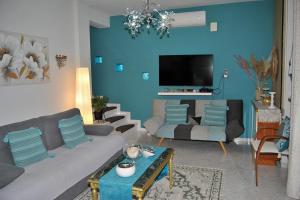 ein Wohnzimmer mit Sofa und Fernseher in der Unterkunft Amalia's Maisonette in Marathos