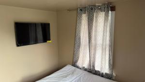 a bedroom with a bed with a curtain and a television at Plattsburgh Stay in Plattsburgh
