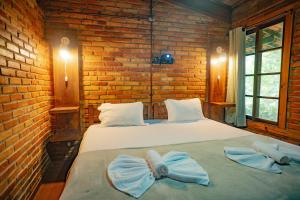 a bedroom with two beds with blue bows on them at Pousada Alto Pirapitinga in Resende +69 photos