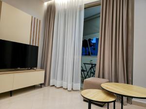 a living room with a television and a table and chairs at A&B Seaside Residence in Golem