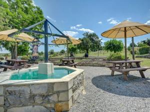 a group of picnic tables and umbrellas at Camping Olé camp in Balazuc