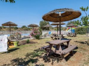 a picnic table with an umbrella and a playground at Camping Olé camp in Balazuc +9 photos