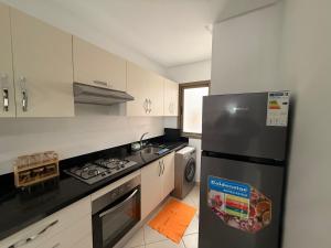 a kitchen with a refrigerator and a stove at Asilah Ocean View Residence in Asilah