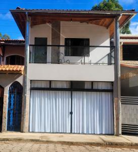 a house with a white garage door with a balcony at Studio Mara Alagoa in Alagoa