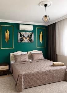 a bedroom with a large bed with a green wall at Lale Residence in Trabzon