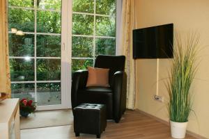 a living room with a chair and a flat screen tv at Ferienwohnung Lüneburger Heide in Schneverdingen