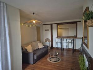 a living room with a couch and a table at Studio Cosy La Parenthèse in Ambérieu-en-Bugey