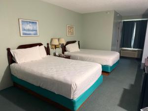 a hotel room with two beds and a window at UP NORTH HOTEL formerly Voyager Inn in Saint Ignace