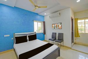 a bedroom with a bed and a blue wall at Hotel O Madhuram Lodge in Siddipet