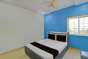 a bedroom with a bed with a blue wall at Hotel O Madhuram Lodge in Siddipet +50 photos