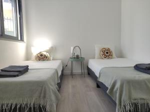 two beds sitting next to each other in a room at Estoril Sun in Estoril