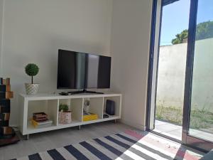 a flat screen tv on a white shelf in a living room at Estoril Sun in Estoril