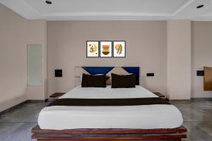 a bedroom with a large bed in a room at Hotel O Dwarkadhish in Surat +21 photos