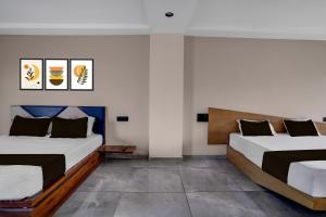 two beds in a room with two at Hotel O Dwarkadhish in Surat