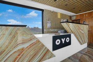 an office with a large window and an ovo sign at Hotel O Dwarkadhish in Surat