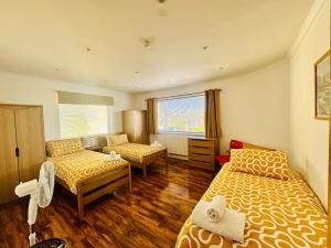 a bedroom with two beds and a couch and a window at Palm Bay Residency in Cliftonville