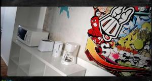 a room with a counter with a microwave and a mural at Le Loft des Remparts in Murat +2 photos