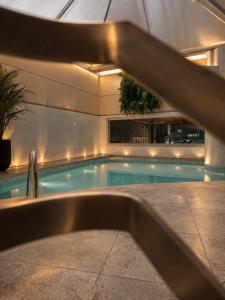 a swimming pool in a building with a sink at Belo Horizonte Plaza in Belo Horizonte