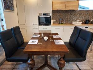 a kitchen with a wooden table and two chairs at North Street Sandgerði in Sandgerði +4 photos