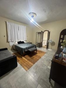 a bedroom with a bed and a chair in a room at Habitación 4 Casa Minerva in Puebla