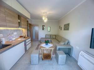 a kitchen and living room with a couch and a table at Parkview Home in Korçë