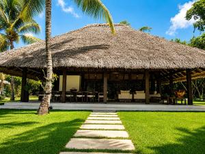 a hut with a grass roof and a pathway at Miara - Celebrity villa in Casa de Campo! in La Romana