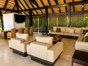 a living room with couches and a flat screen tv at Miara - Celebrity villa in Casa de Campo! in La Romana