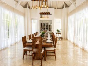 a dining room with a long table and chairs at Miara - Celebrity villa in Casa de Campo! in La Romana