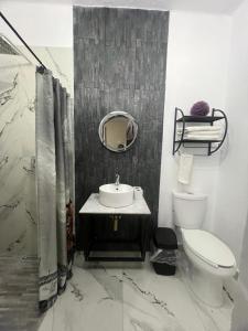 a bathroom with a sink and a toilet and a mirror at Habitación 4 Casa Minerva in Puebla