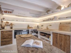 a kitchen with a counter with an open book on it at C'an Llum in Deia
