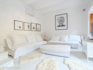 a white room with two beds and a couch at C'an Llum in Deia