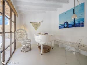 a white dining room with a table and chairs at C'an Llum in Deia +14 photos