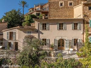 an old house with a palm tree in the background at C'an Llum in Deia