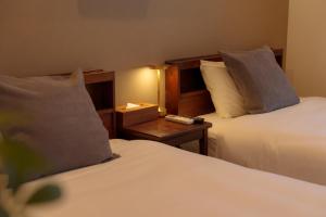 a hotel room with two beds and a night stand at Solis Studio Miyako SeaSide in Miyako-jima +42 photos