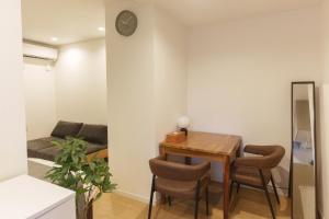 a living room with a wooden table and chairs at Solis Studio Miyako SeaSide in Miyako-jima