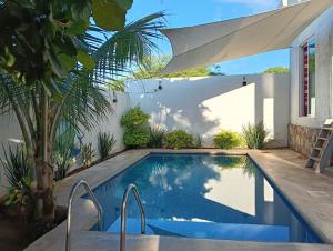 a swimming pool in a backyard with a patio umbrella at Casa Marbo in Malucano