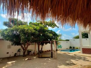 a house with a swimming pool and a straw umbrella at Casa Marbo in Malucano