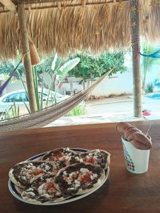 a pizza on a plate on a table with a drink at Casa Marbo in Malucano
