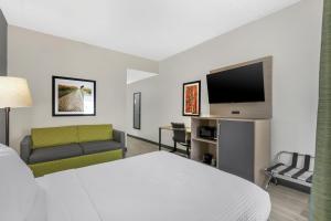 a hotel room with a bed and a flat screen tv at Best Western Eagles Inn in Morehead