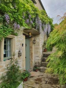 a stone house with a green door and flowers at Lamb Cottage Bed and Breakfast in Box