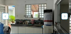 a kitchen with a counter with a sink and a window at Nosso lar hostel in Cuiabá