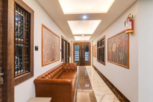 a hallway with a couch in a room with paintings at HOTEL O PRAGATI in Gorakhpur