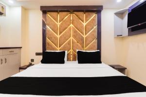 a bedroom with a bed and a wooden headboard at HOTEL O PRAGATI in Gorakhpur +57 photos