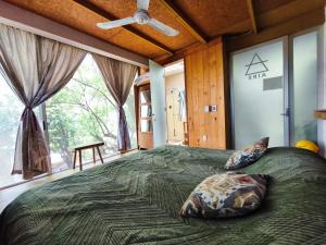 a bedroom with a green bed with two pillows on it at Casa Santi Tepoztlán in Tepoztlán +3 photos