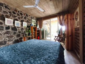 a bedroom with a bed and a stone wall at Casa Santi Tepoztlán in Tepoztlán