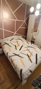 a bed in a room with a wall at Apartment Grandis in Škaljari