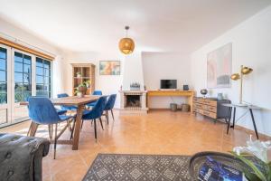 a living room with a wooden table and chairs at Quinta da Mina 13 in Azambuja +53 photos