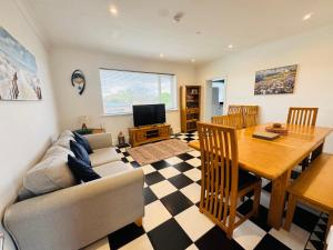 a living room with a dining room table and a couch at Palm Bay Residency in Cliftonville
